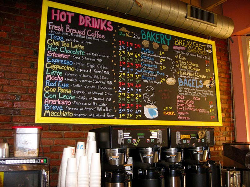 a colorful handwritten menu on a chalkboard in a coffee shop