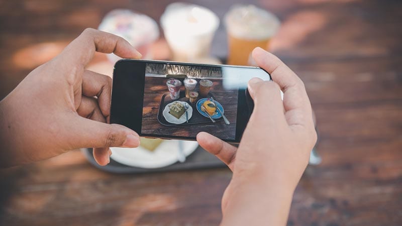 woman taking picture of food and coffee drinks