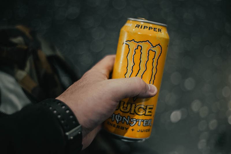 hand holding a can of juice monster energy