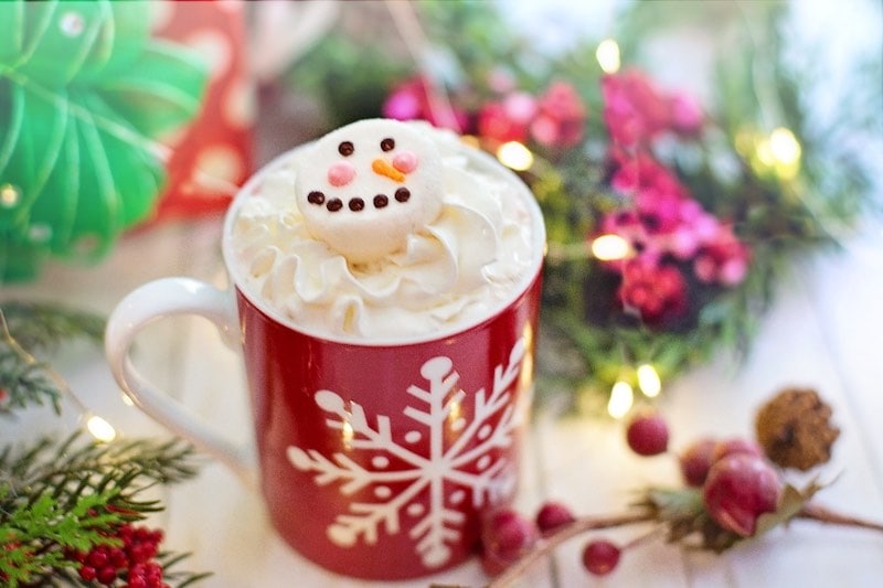 святковий білий гарячий шоколадний напій зі сніговиком на збитих вершках