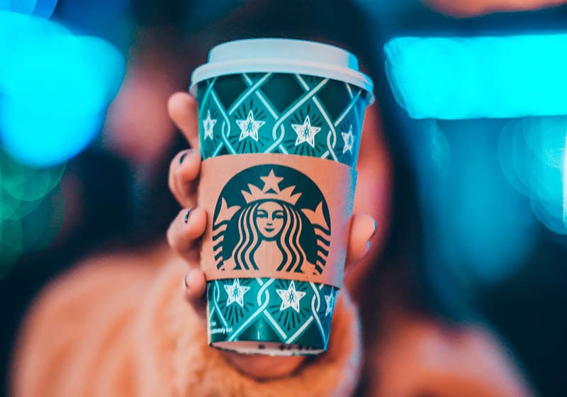 person holding a cup of festive Starbucks drink