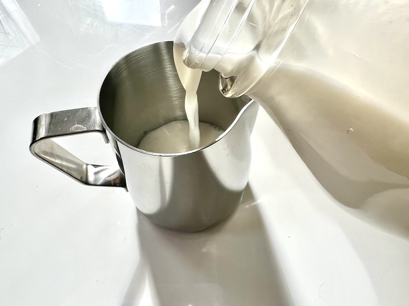 hælde mælk i latte art dampende kande