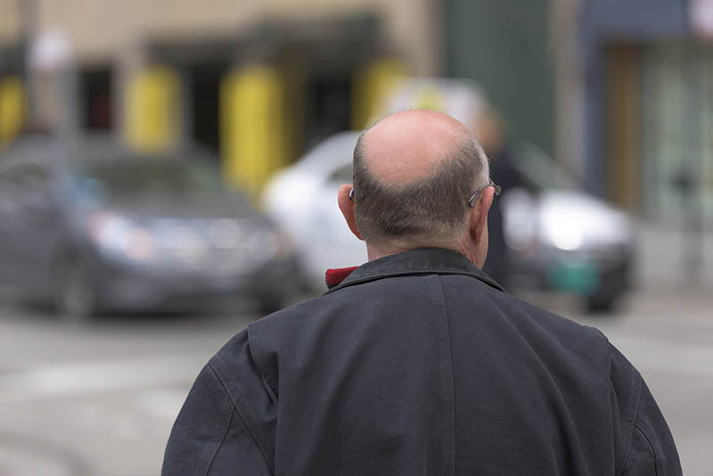 bald man walking in the street