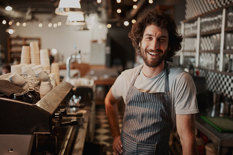 male coffee shop owner standing behind counter