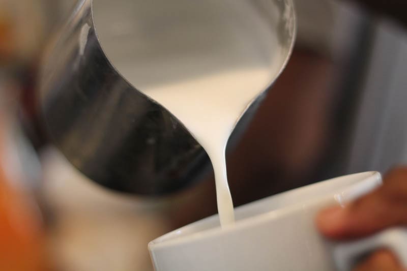 pouring textured milk to the cup