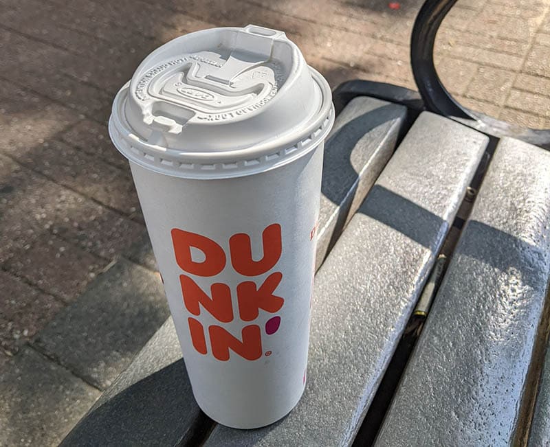 a cup of dunkin on the bench