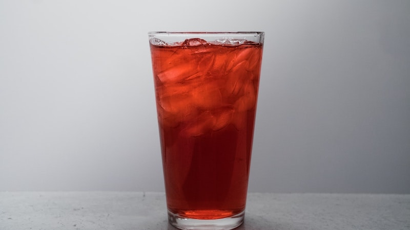 красный чай со льдом в высоком стакане