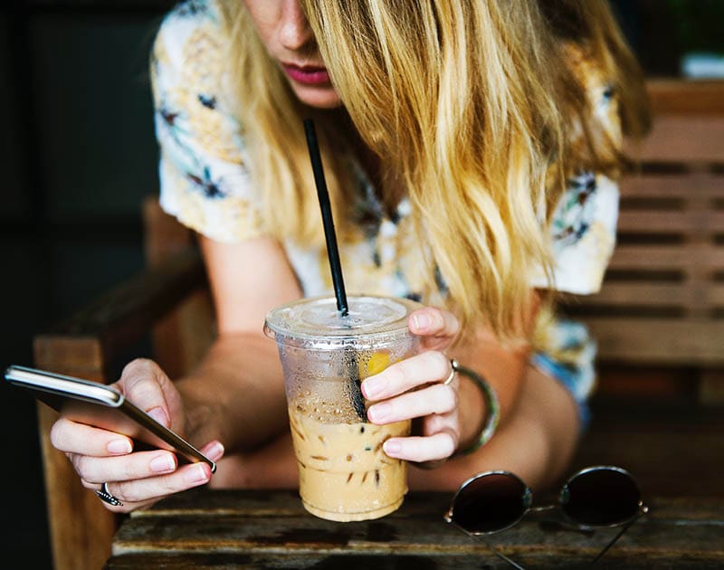 woman drinking iced coffee