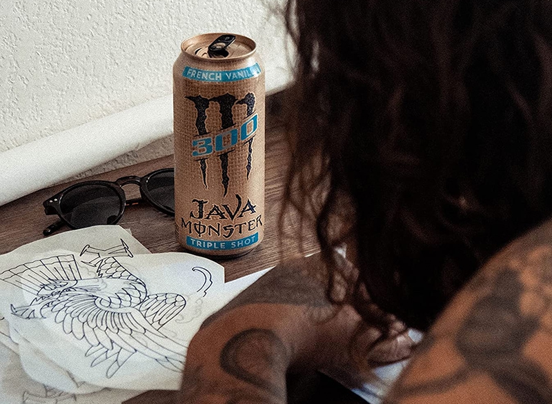 Monster Energy Java 300 Triple Shot Robust Coffee in front of a tattooed person