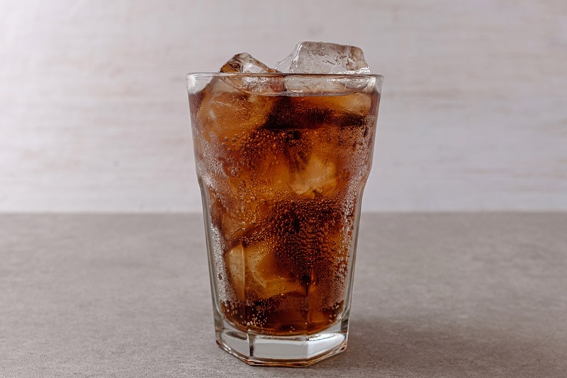 a glass of cola with ice